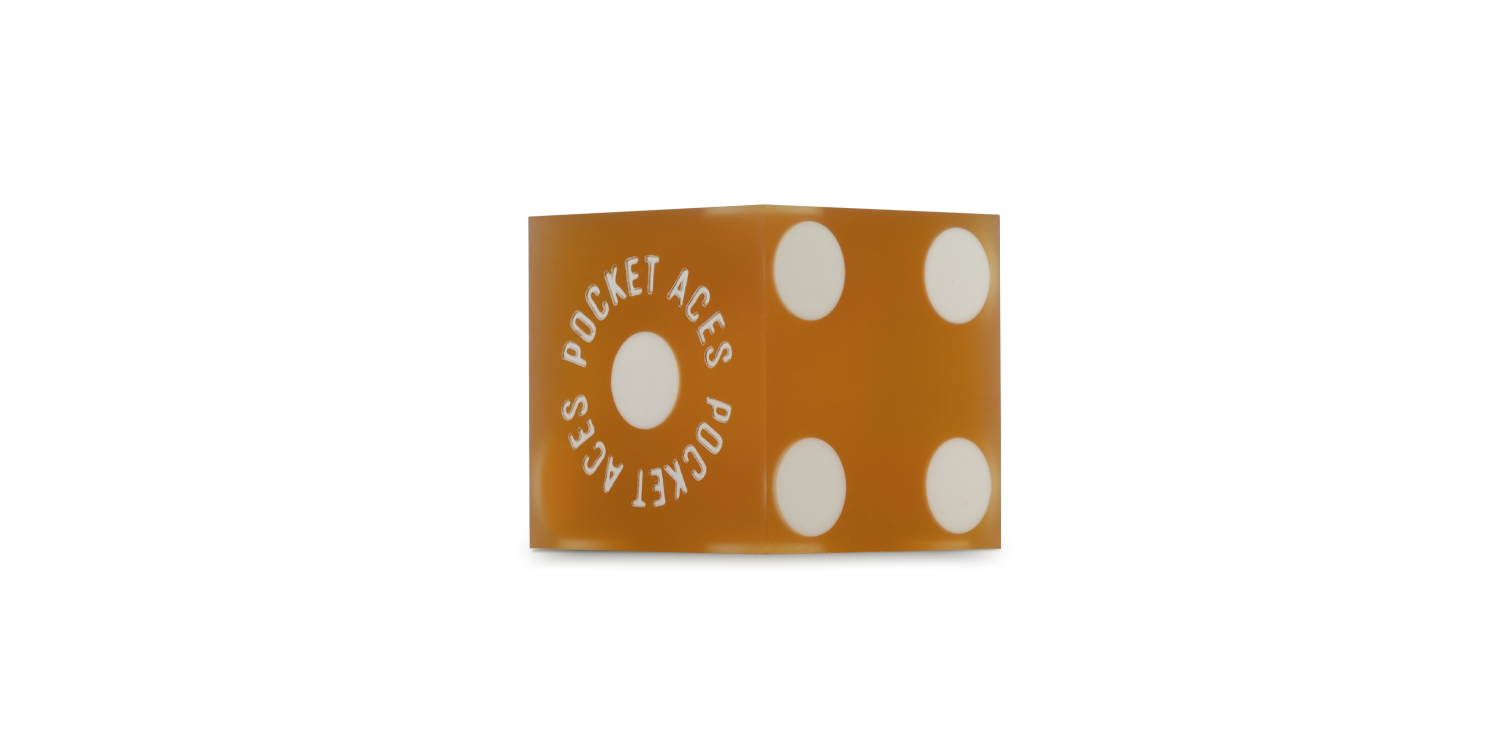 A sanded casino die in a honey color
