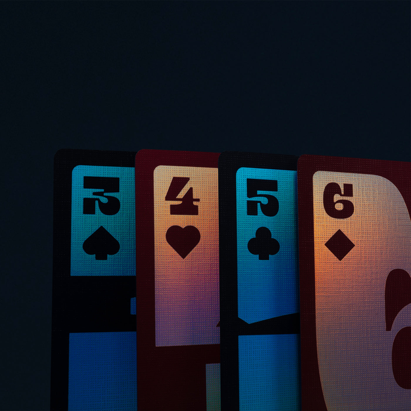 Four playing cards with numbers and suits on a dark background
