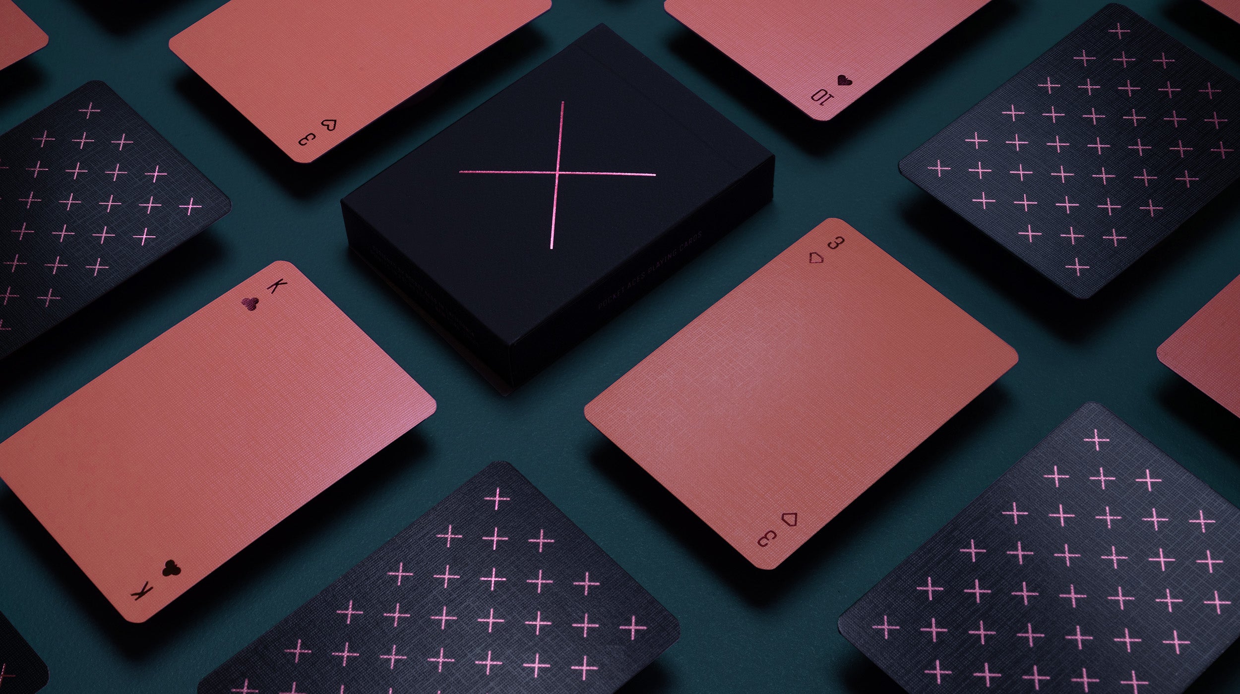 A coral deck of playing cards on a table