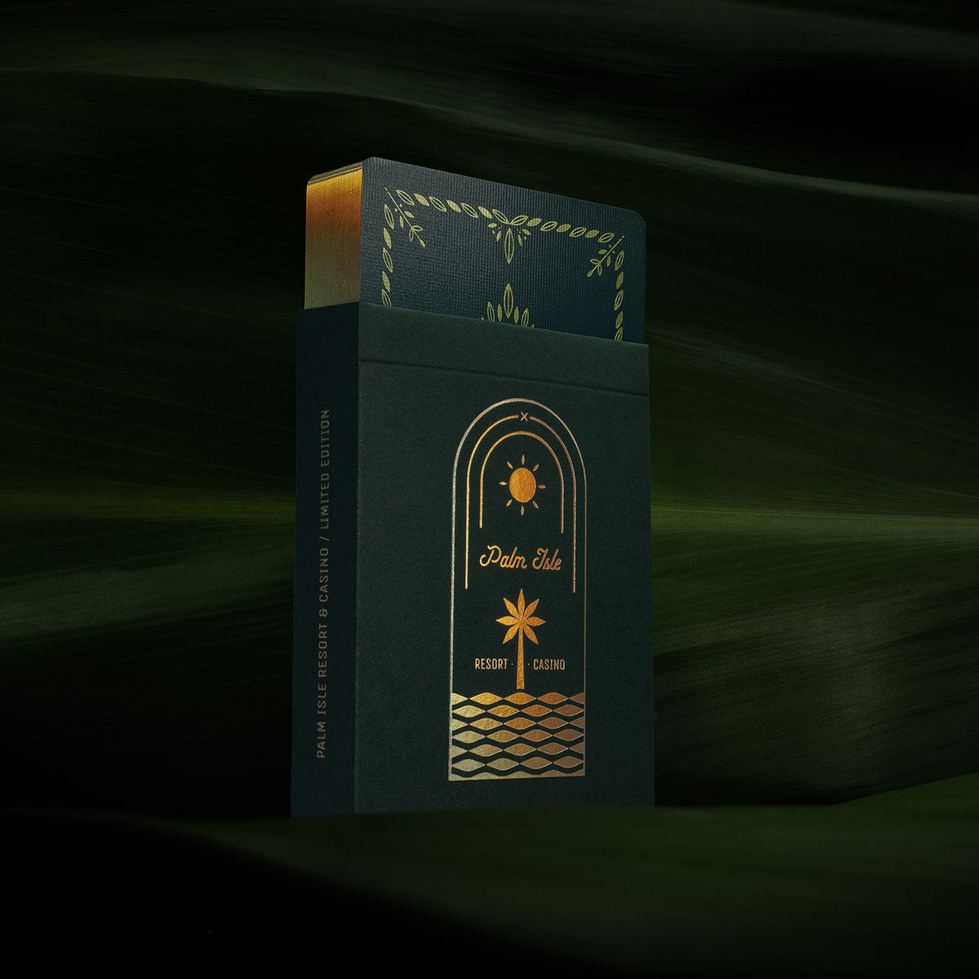 A deck of holographic foiled cards against a backdrop of palm fronds
