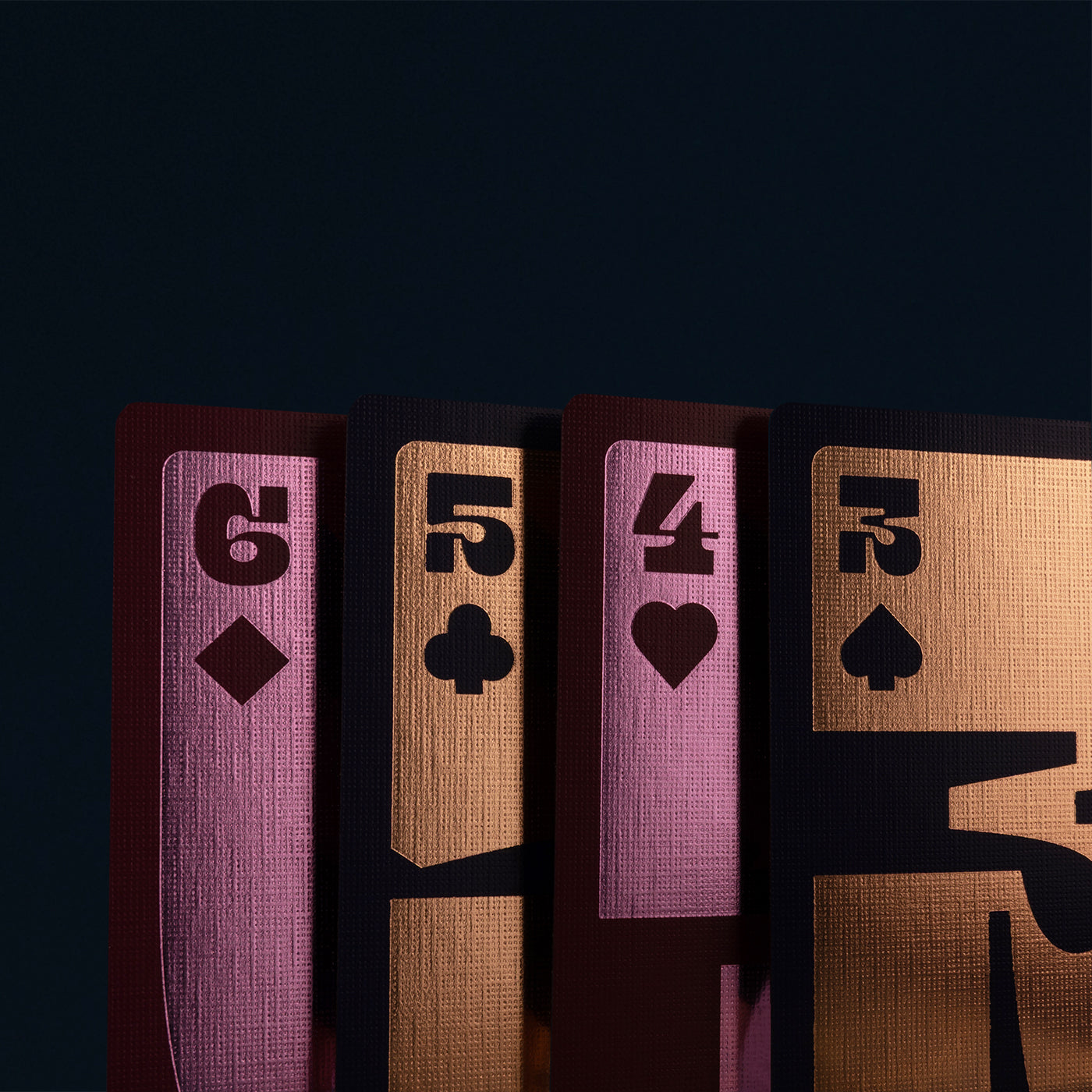 Four playing cards with different suits and numbers on a dark background